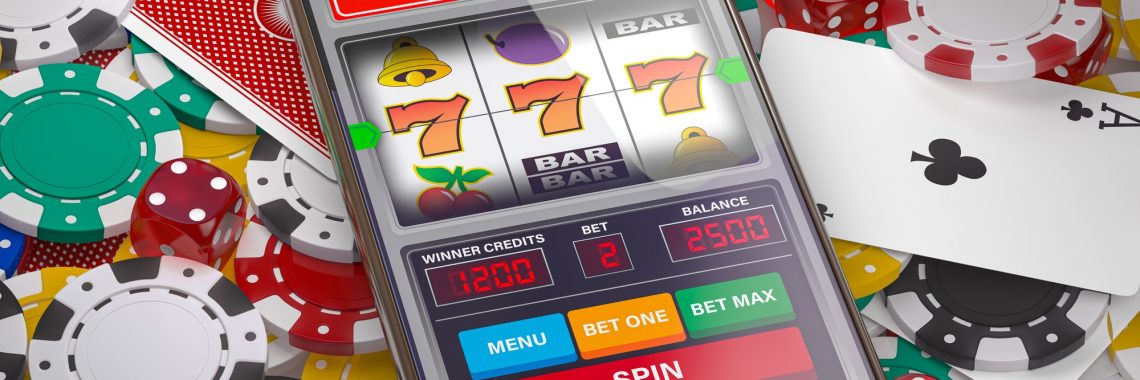 Online casino. Slot machine on smartphone screen, dice, casino chips and cards.